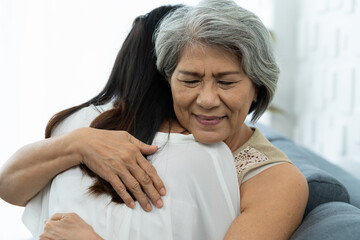 Close up happy older mature mother embracing young grownup daughter with kindly. Young woman carefully takes care of old woman. Elderly mum and grownup daughter hugging together at home