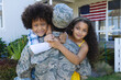 © WavebreakMediaMicro - Portrait of excited multiracial boy and girl embracing military father returned home
