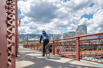 Wall Mural - Cyclist amateur woman of athletic fit make a bike ride along the bike path on the bridge of the modern city