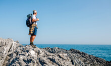 Senior Man With Backpack Hiking Looking At Sea Landscape