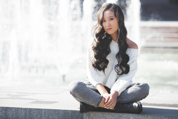 Wall Mural - Beautiful woman outdoors. Pretty lady on urban background. Asian female closeup portrait.