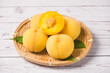 ripe yellow peaches with half on white wooden table