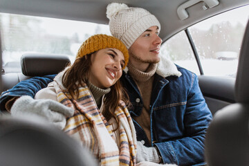 Canvas Print - people, love and leisure concept - happy smiling couple hugging on car back seat in winter