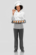 © Syda Productions - cooking, culinary and bakery concept - happy smiling female chef or baker in white toque and jacket holding baking tray with oatmeal cookies over grey background