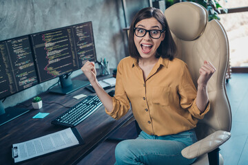 Wall Mural - Portrait of attractive ecstatic cheerful lucky girl having fun developing web project startup at workplace workstation indoors