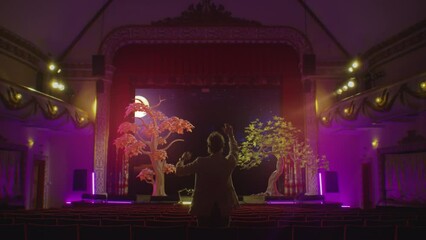 Innovation technology concept for creative: A director in a theater in a vr headset uses augmented reality software to simulate and create scenery in a 3d virtual space for a future performance.