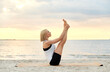 Leinwandbild Motiv fitness, sport, and healthy lifestyle concept - woman doing yoga boat pose on beach over sunset