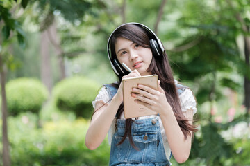 Fototapete - Young Asian teenage girl with tablet and notebook