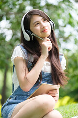 Fototapete - Young Asian teenage girl with tablet and notebook
