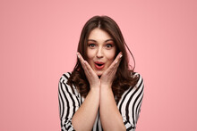 Surprised Young Lady Shouting And Touching Cheeks Against Pink Background