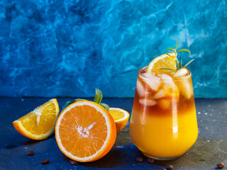 Wall Mural - cold bumble coffee. refreshing espresso coffee with orange juice and ice on a blue background. orang