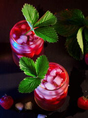 Wall Mural - two summer strawberry cocktails with ice . decorated with a strawberry leaf. top view, selective foc