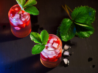 Wall Mural - two summer strawberry cocktails with ice . decorated with a strawberry leaf. top view, selective foc