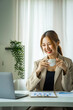 © crizzystudio - Young beautiful Asian businesswomen drinking coffee and using a computer laptop