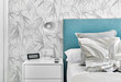 Cosy bedroom with grey pillows,  turquoise headboard and white bedside table