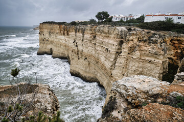 Wall Mural - View from the mountain edge to the moody sky, raging Atlantic Ocean during stormy weather. Portugal