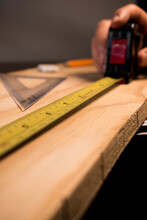 Carpenter Taking Wooden Table Measurements With Some Tools 