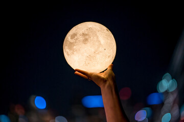 hand grabbing the moon at night