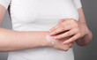 Woman applying pain relief gel on sprained wrist for swelling and inflammation reduction. Arm injury, chronic disease. Health care concept. High quality photo