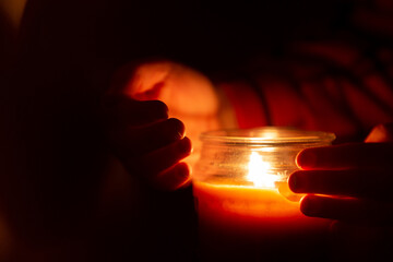 Wall Mural - Hands holding candle in dark