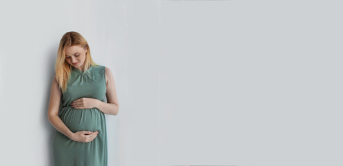 Poster - Young pregnant woman touching belly on light background, space for text. Banner design