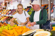 © JackF - Positive father and his teenage daughter doing grocery shopping, choosing fresh oranges