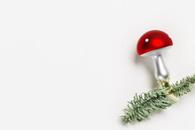 Christmas Botanical Ornaments Fly Agaric Mushrooms With Red Cap And White Dots, On Natural Green Christmas Fir Tree Branches On White Background With Copy Space. Holiday Winter Decor