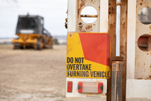 Rear Of Truck With Warning Sign And Blurred Machine In Background