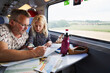© FOLIO - Father and daughter looking at map on train
