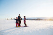 © FOLIO - Family standing in snow while skiing