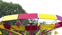4k video real time.kids are having fun on carousel in a public park,summer time.children's swinging in air,carousel wheel spins.rotating chair swing