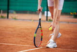 Fototapeta Sport - Female tennis player legs in tennis shoes standing on a clay court.