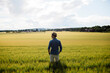© FOLIO - Young man in hat standing in field