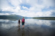Brother Wading Across Ottsjo Lake In Valadalen Nature Reserve Sweden