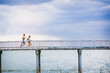 © Panumas - Young couple running together on road across the bridge. Couple, fit runners fitness runners during outdoor workout.