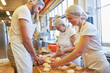 © Robert Kneschke - Bäcker Lehrlinge und ältere Kollegin backen Brötchen