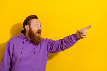 Wall Mural - Photo of funny impressed guy dressed purple sweater looking pointing finger empty space isolated yellow color background