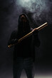 Silhouette of african american bandit with mask on face holding baseball bat on black background with smoke