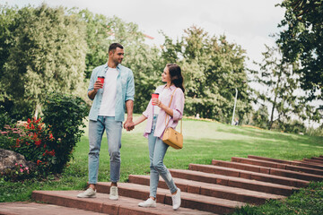 Poster - Photo of charming dreamy boyfriend girlfriend wear casual outfits walking stairs drinking beverages enjoying sunny outdoors garden