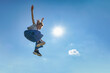 canvas print picture - Outdoor photo of young caucasian teenager jump with blue sky background.