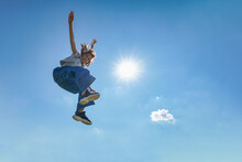 Outdoor Photo Of Young Caucasian Teenager Jump With Blue Sky Background.