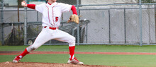 High School Baseball Pitcher In Full Wind Up Pitching During A Game