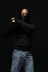 Wall Mural - African american hooligan in gloves and face mask holding baseball bat isolated on black