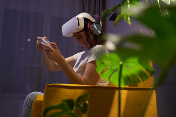 Wall Mural - Woman with virtual reality headset and joystic is playing game.