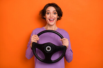 Sticker - Positive excited lady hold wheel drive fast have good mood isolated on orange color background