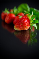 Wall Mural - Ripe juicy red strawberry on black background