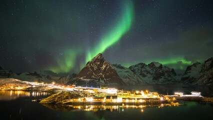 Wall Mural - time lapse of aurora borealis dancing on mountains with fishing village.