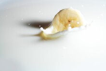 Closeup Of A Banana Slice Splashing In The Milk