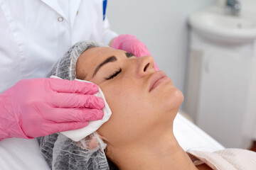 Woman having cleaning facial treatment in spa