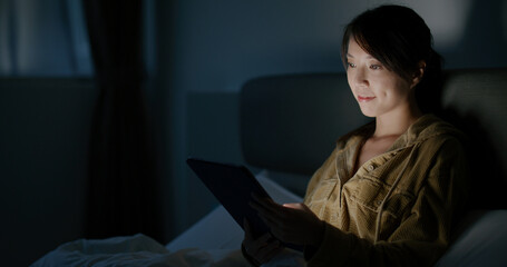 Canvas Print - Woman work on tablet computer and lying on bed at night